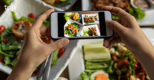 Two hands take a photo of food in front of them to promote catering software and SEO tips